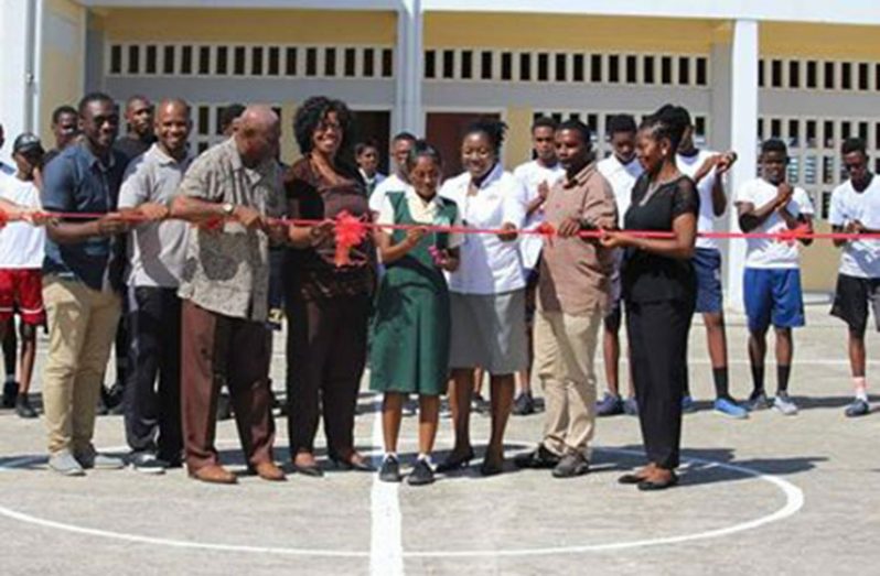 Officials participate in the cutting of the ribbon to open the Leonora Secondary Basketball Court.
