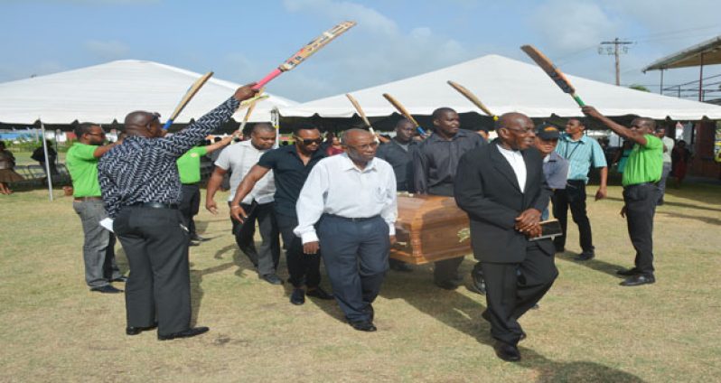 Pastor Kemuel Rock leads the casket borne by media colleagues and GCB officials to the Merriman’s Funeral hearse for his final resting place. (Samuel Maughn photo)