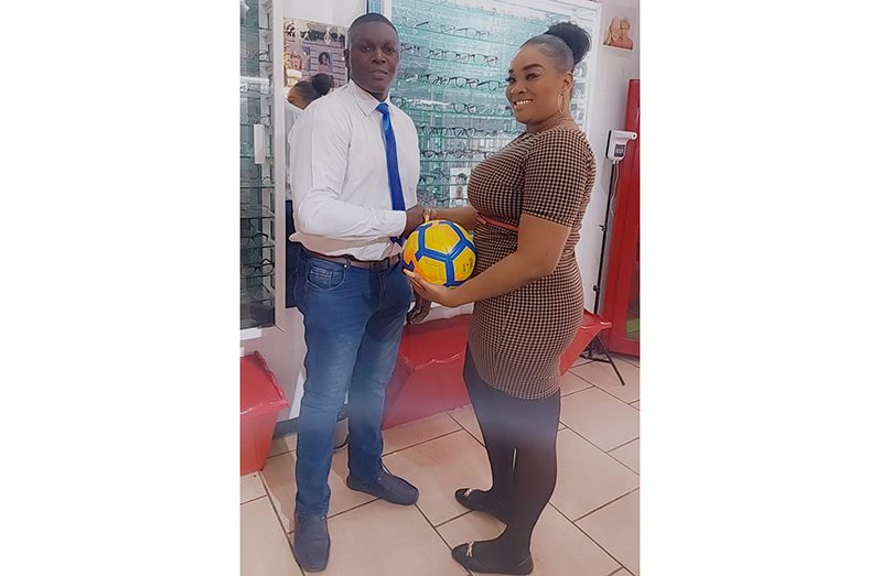 Secretary of Victoria Kings Football Club - Calvin Marks receiving one of the footballs from Melissa Sanmoogan of Sears 2020 Vision Centre at their 101 Regent and Cummings Streets Branch, Georgetown.