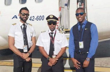 Rhinold Cameron (right) clad in his flight attendant's uniform moments before a trip with two of his workers before the coronavirus pandemic