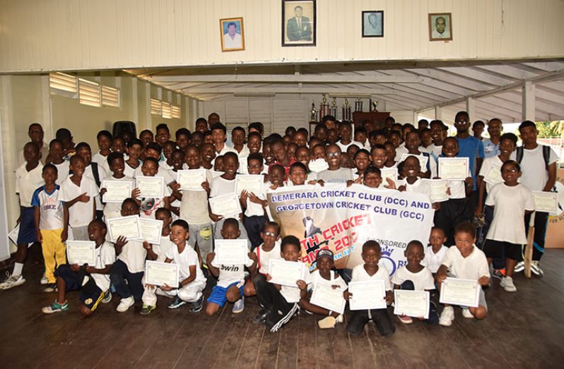 Youngsters who participated in the DCC/GCC youth camp pose with the coaches. (Adrian Narine photo)