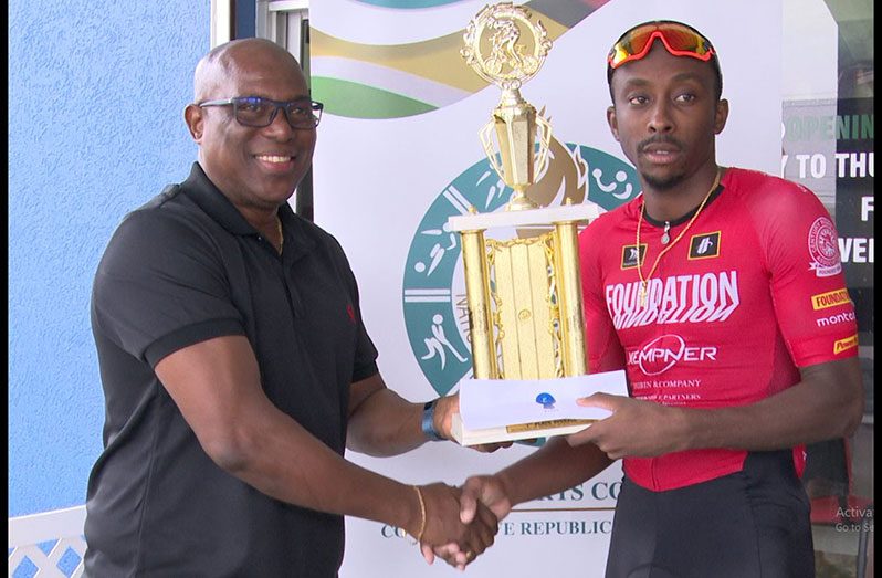 Trinidadian Ability Campbell (right) collects his trophy from the director of sport, Steve Ninvalle