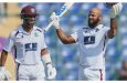 John Campbell (right) celebrates after scoring his maiden Test century, while Shai Hope looks on
