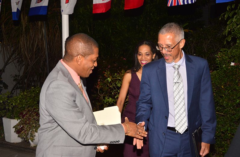 Minister of Business Dominic Gaskin engages Head of the Department of Energy of the Ministry of the Presidency, Dr Mark Bynoe, during the reception (Adrian Narine photo)