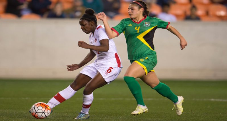 Deanne Rose, who scored twice in her team’s win over Guyana, being defended by Kayla De Souza.