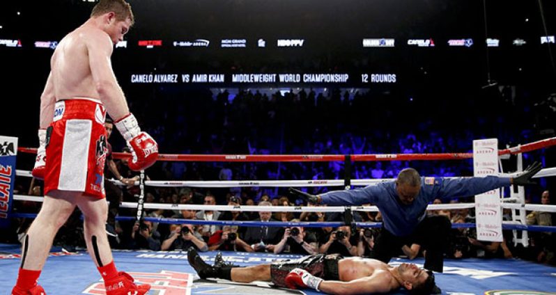 Canelo Alvarez watches as the referee counts out a prone Amir Khan.
