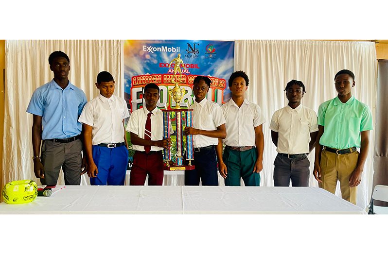 Team captains from seven of the eight participating schools, along with the championship trophy for this year’s ExxonMobil Linden Inter-school football tournament.