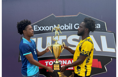 The captains of YMCA Keyshawn Dey (right) and Silver Bullets Rodensio Tudor face-off with the coveted championship trophy ahead of tonight’s final