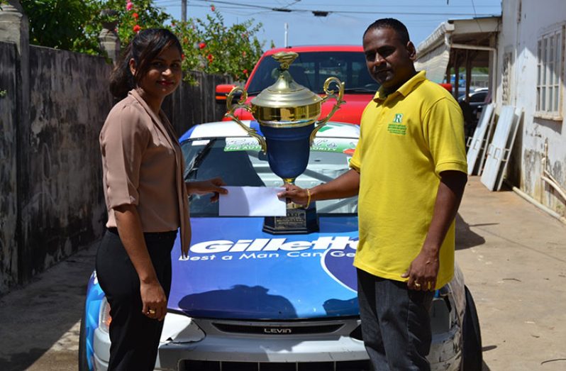 Anand Ramchand collects a sponsorship package from Proctor and Gamble co-coordinator Diana Ally.