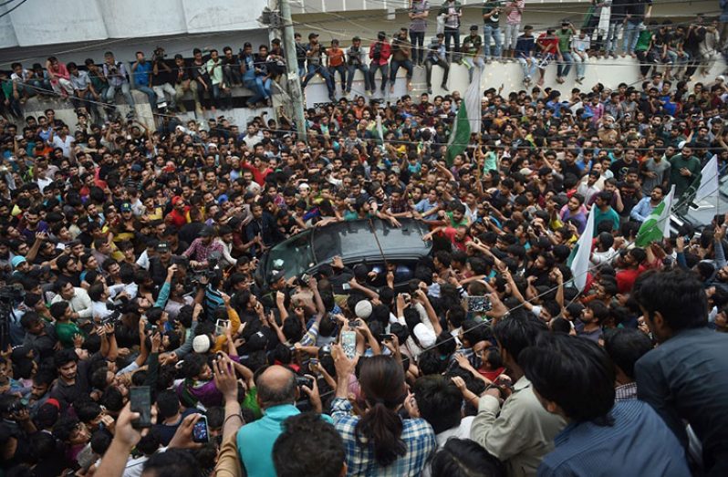 Pakistan captain Sarfraz Ahmed's car inches through a sea of people in  Karachi yesterday.