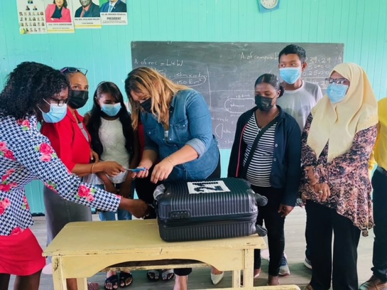 Minister of Education, Priya Manickchand, handing over the suitcase of cash to several teachers and parents at the Cotton Field Secondary. Also pictured is Regional Education Officer, Nichola Matthews (left)