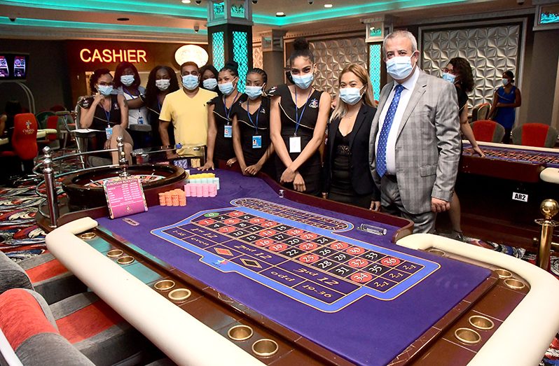 Owner of the Sleepin Group, Clifton Bacchus flanked by his employees in one section of the extravagant casino