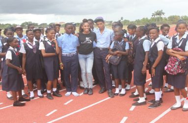 Kristi Castlin is flanked by students of Leonora Secondary yesterday. (Sonell Nelson photo)