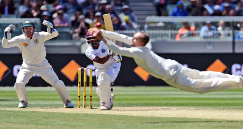 Australian spinner Nathan Lyon flies through the air in an attempt to catch West Indies batsman Rajendra Chandrika, with wicketkeeper Peter Nevill looking on. Photograph: William West/AFP/Getty Images