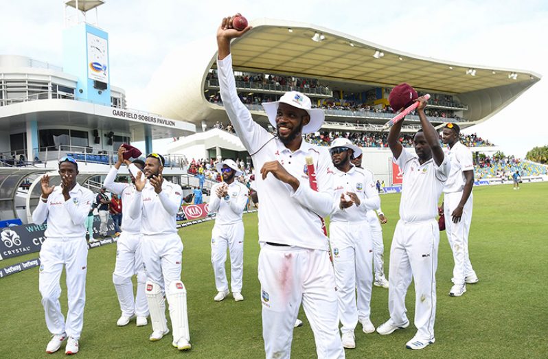 Roston Chase leads his team-mates in a victory lap. With figures of 21.4-2-60-8, Chase was West Indies' unlikely bowling hero on another memorable day. (AFP)