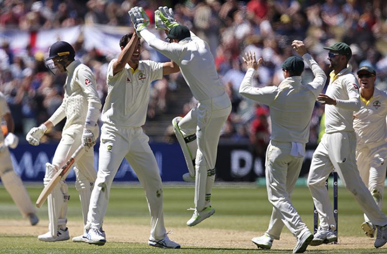 Teammates celebrate with pacer Mitchell Starc after taking the wicket of England's Craig Overton, left, during the fifth day of their Ashes Test match in Adelaide, yesterday.