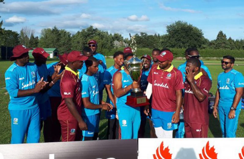 The victorious West Indies B players and officials pose with the winners’ trophy.