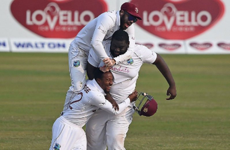 John Campbell (top) and Kavem Hodge engulf Rahkeem Cornwall as they celebrate a wicket on the dramatic final day of the second Test.