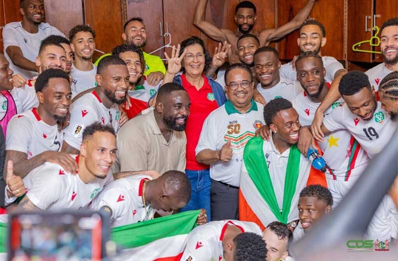President of Suriname Jenny Simons and vice-president Gregory Rusland (centre), celebrate with the Natio players in the locker room after their victory over El Salvador