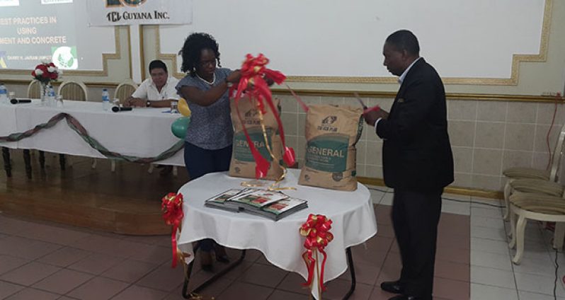 TCL Marketing and Sales Assistant Latoya Greaves assisting General Manager (International Business and Marketing) for TGI Egwin Daniel in cutting the ribbon to officially unveil the new cement packaging