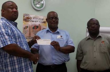 Here you go, sir! The company’s Sales and Marketing Representative Eric Whaul (right) observes the proceedings, Plant Manager of TCL Mark Bender (center) presents the cheque to Secretary/Chief Executive Officer (CEO) of RHTYSC Hilbert Foster.