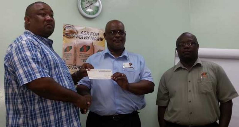 Here you go, sir! The company’s Sales and Marketing Representative Eric Whaul (right) observes the proceedings, Plant Manager of TCL Mark Bender (center) presents the cheque to Secretary/Chief Executive Officer (CEO) of RHTYSC Hilbert Foster.