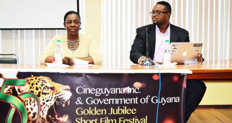 Minister within the Ministry of Education, with responsibility for Youth, Sport and Culture, Nicolette Henry, making a point while CeneGuyana President Phillip Williams looks on at the launch of the Golden Jubilee Film Festival on Friday (Photo compliments of the Ministry of Education)