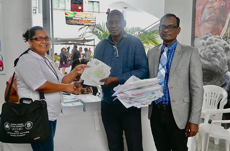 Minister of Home Affairs, Robeson Benn hands over several birth certificates to a Toshao who collected on behalf of villagers of Mabaruma, North West District, Region One, in the presence of Deputy Registrar General, Visham Budhoo