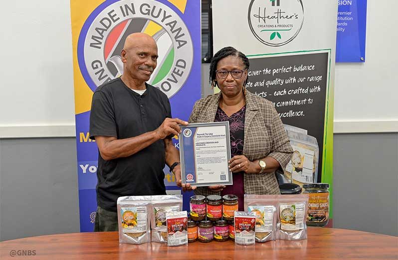 Heather and her spouse, Richard Thompson, posing with their latest certificate of the Made in Guyana Standards Mark issued by the GNBS