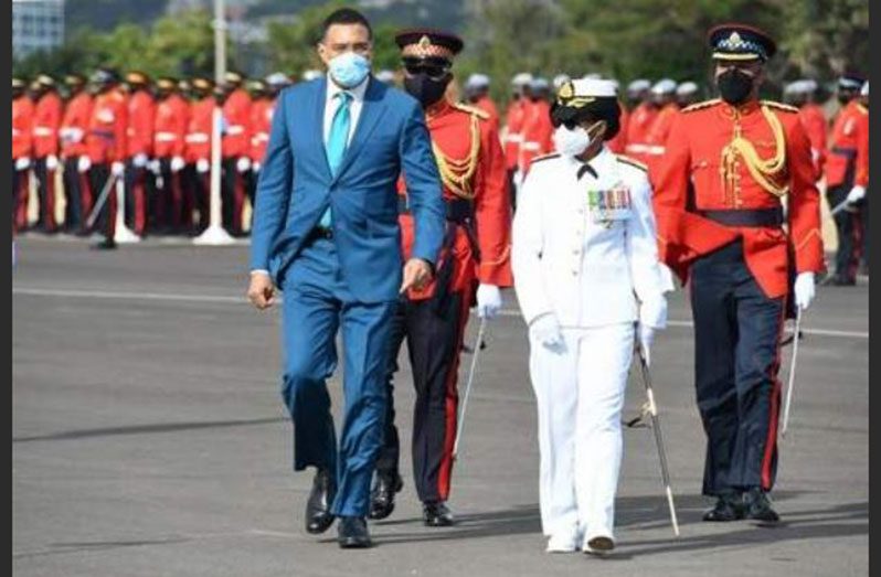 First female Chief of Defence Staff (CDS), Rear Admiral Antonette Wemyss-Gorman and Prime Minister Andrew Holness walk together at the JDF's 12th change of Command Parade. (Photo credit: Jamaica Observer/ Garfield Robinson)