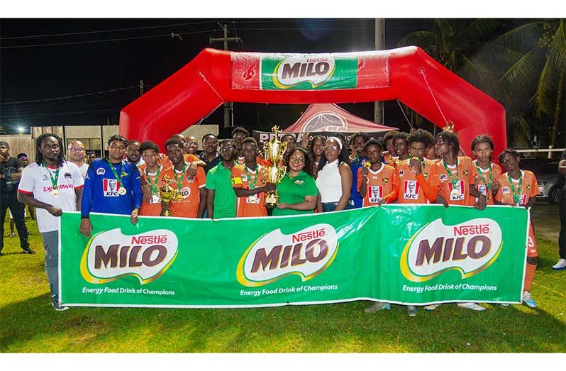 Dolphin Secondary players celebrate with the trophy after their title win