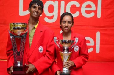 Flashback! We are the champions! Proudly decked out in their ‘Red Jackets’ 2013 Digicel Golf Open Champions Arvinda Kishore (male) and Christine Sukhram display their spoils after claiming the top prizes last year. Will this be the scene this Sunday when the action culminates. (Photo by Adrian Narine)