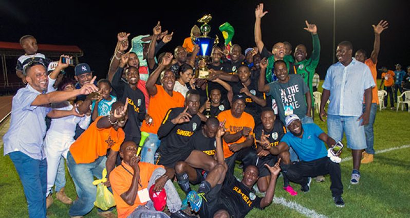 New football Kings of Guyana, Slingerz FC, and fans celebrate their 1-0 victory that dethroned Alpha United last Sunday night. (Samuel Maughn photo)