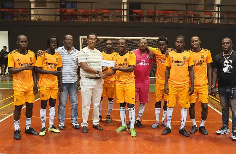 The victorious Back Circle unit receives their prize after successfully defending their title following a 4-2 win over Gold is Money in the final of the Rock Futsal Championship.