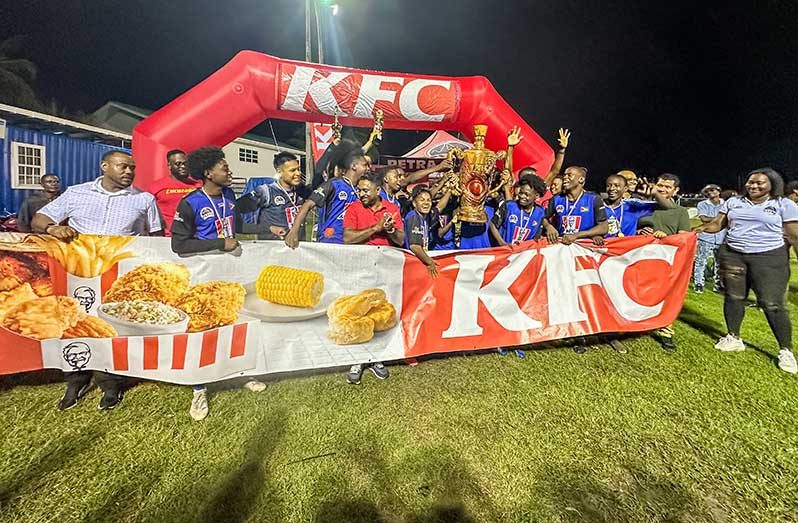 Chase Academy celebrating winning the KFC Goodwill Intl Sec School Football Championship trophy with KFC and Petra officials.