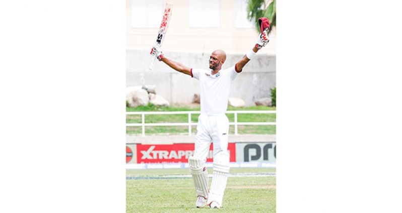 Roston Chase raises his bat after bringing up his maiden Test hundred © WICB Media Photo/Athelstan Bellamy