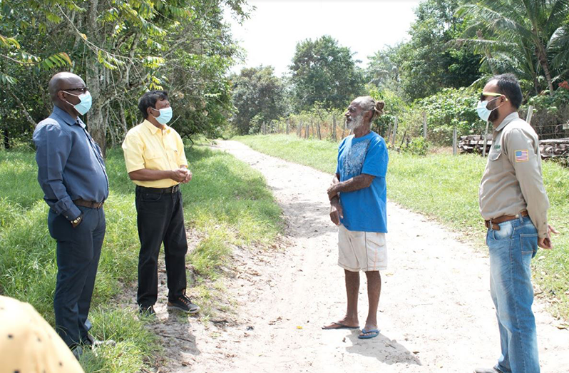 GWI CEO, Shaik Baksh (second left) engages a Moblissa resident, Tangamu Ngquondo (second right)