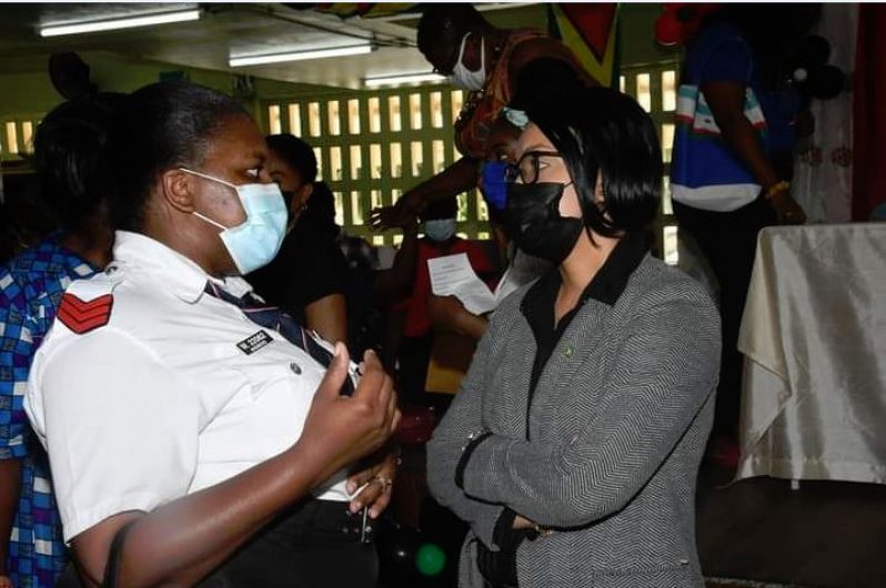 Minister within the Ministry of Housing and Water, Susan Rodrigues, interacts with a parent during the distribution exercise