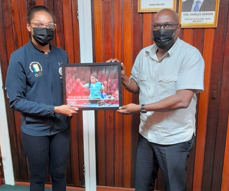 Chelsea Edghill (at left) makes a presentation to Director of Sport, Steve Ninvalle, as a token of appreciation for the National Sports Commission's assistance.