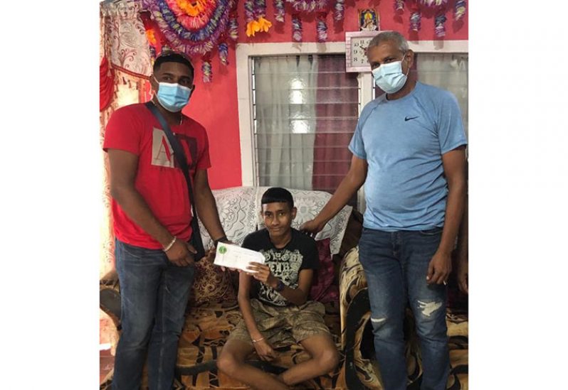 West Dem Masters Chabiraj Ramcharran (left) and Mohamed Abid Haniff presenting $100,000 to assist Aditya Mohabir (centre) with dialysis