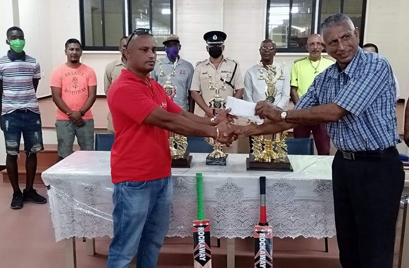 Mr Gray Ghadgat (left)  makes the presentation to ECCB secretary, Mr. Anandjit, in the presence of Commander Pareshram and other sponsors.