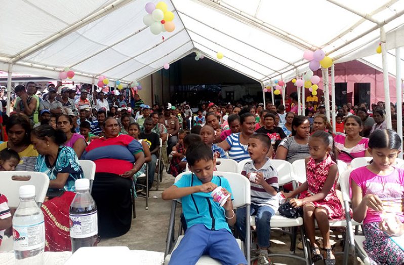 Spreading the Christmas spirit: These adults and children of Skeldon, Berbice, had a grand time at the Private Sector Commission’s (PSC) toy and hamper distribution exercise on Friday