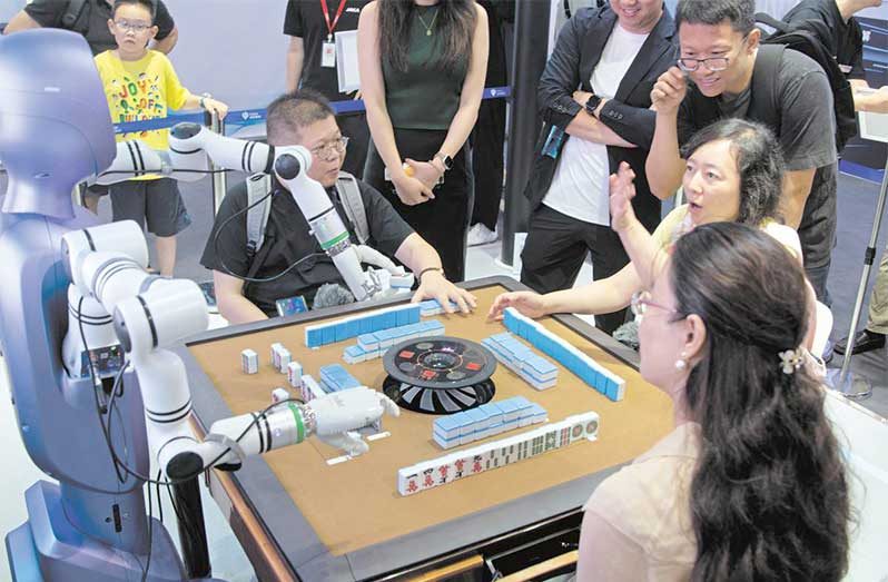 Visitors play mahjong on Saturday with a PsiBot humanoid robot at the opening of the 2025 World Artificial Intelligence Conference and High-Level Meeting on Global AI Governance in Shanghai (Ying Tang/Getty Images)