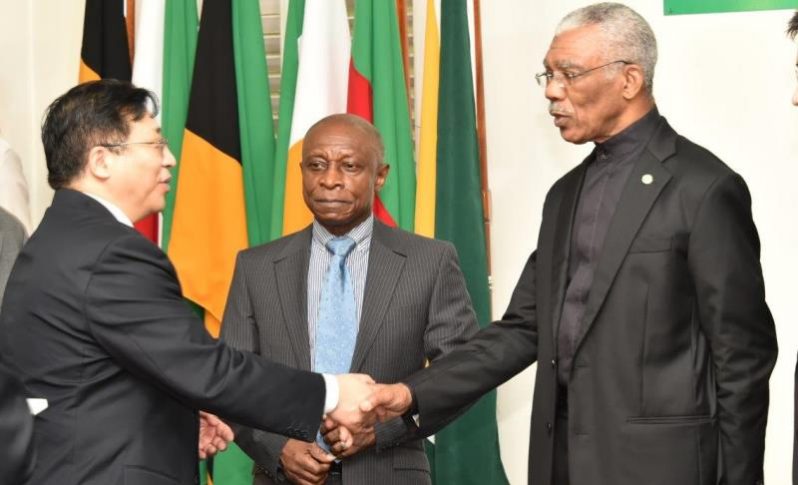 President David Granger and newly accredited Ambassador to Guyana, Mr. Cui Jianchun exchanges a handshake as acting Prime Minister and Minister of Foreign Affairs, Mr. Carl Greenidge looks on.