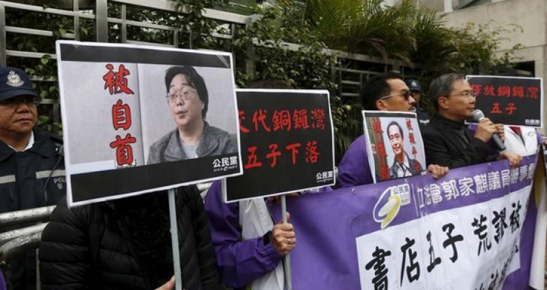 Members from the pro-democracy Civic Party carry a portrait of Gui Minhai (L) and Lee Bo during a protest outside the Chinese Liaison Office in Hong Kong, China January 19, 2016. REUTERS/Bobby Yip.