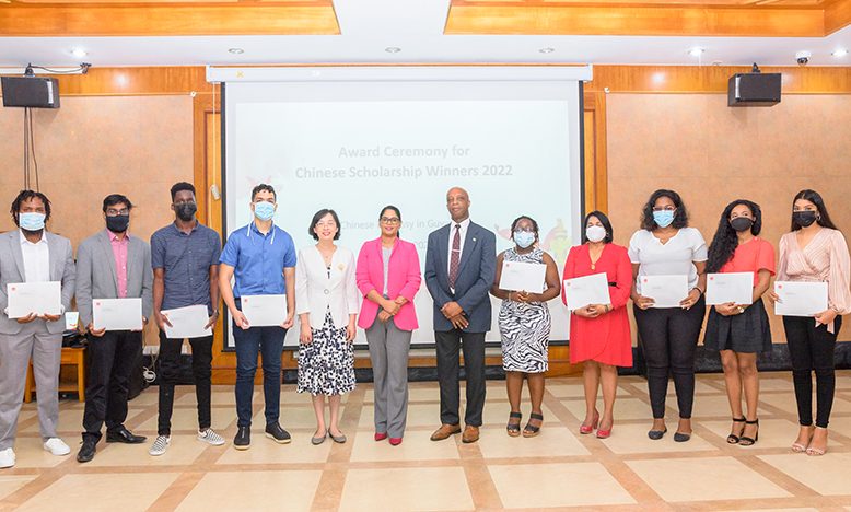 Some of the awardees of the Chinese Scholarships for 2022 pictured with Minister of Public Service, Sonia Parag (standing at centre), Ambassador of China to Guyana, Guo Haiyan (fifth from left) and Director of the Department of International Co-operation at the Ministry of Foreign Affairs, Forbes July (sixth from right) (Delano Williams photo)