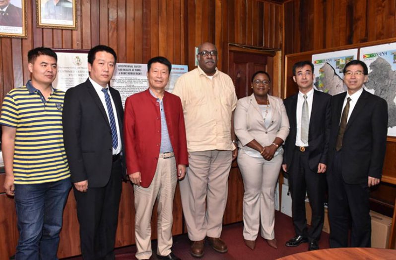 Minister within the Ministry of Natural Resources Simona Broomes and GGMC‘s Commissioner (ag) Newell Dennison stand with representatives of the Chinese delegation on Wednesday in the GGMC’s boardroom