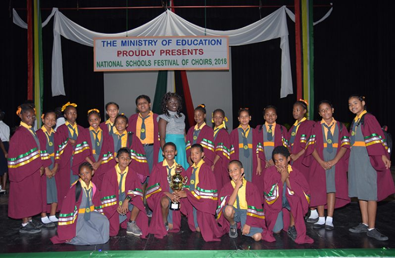 Supply Primary School Choir emerged winner of the Ministry of Education National Schools Festival of Choirs held on Tuesday at
the National Cultural Centre. The Bishops High School won the secondary category. In this Samuel Maughn photo the members
of the Supply Primary School Choir and their instructor pose with their winning trophy