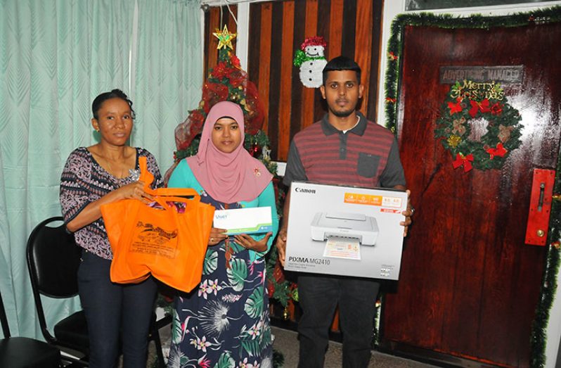 Winners: Nicola Softly, Mobeena Amin and Rajendra Khemraj pose with their prizes at the Guyana Chronicle on Friday