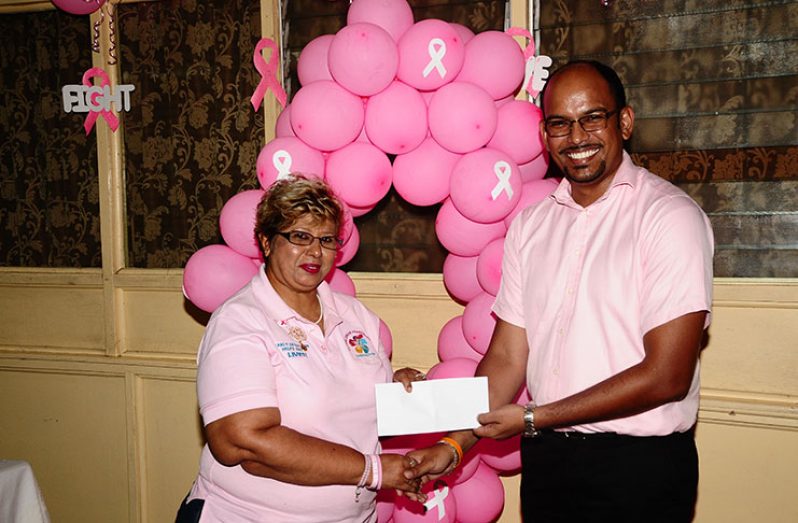 Guyana Chronicle Deputy Chief Reporter Rabindra Rooplall makes a contribution on behalf of the GNNL to Bibi Hassan, of the Guyana Cancer Foundation